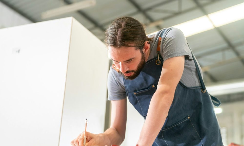 Carpenter working on the woodworking desk and furniture handmade with wood